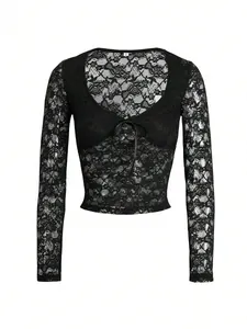 Détail de la dentelle florale délicate et du lien à nouer sur un crop top noir à manches