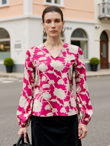 Detail of V-neck floral blouse with elastic cuffs on a magenta printed long sleeve shirt