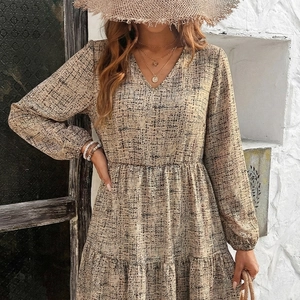Elegant beige V-neck long sleeve dress with black abstract print and cinched waist