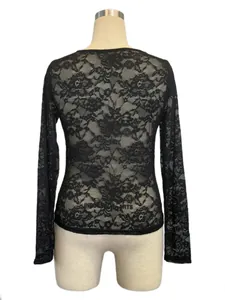 Dettaglio del retro di una maglia nera in pizzo a maniche lunghe con fiori ricamati