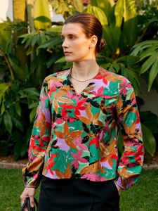 Detail of multi-color floral print V-neck shirt with elastic cuffs and vibrant patterns