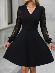 Detail of elegant black dress showing intricate floral lace sleeves and V-neckline