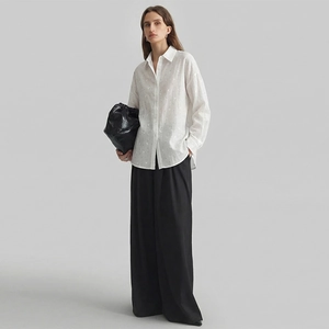 Elegant white long sleeve crepe shirt with black wide leg trousers and fashion handbag