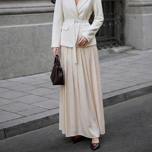 Elegant women's cream blazer with belted waist and matching pleated satin midi skirt