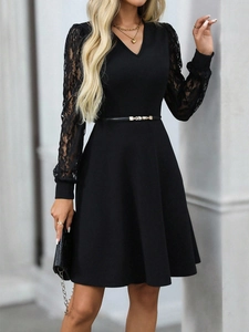 Detail of elegant black V-neck dress featuring delicate floral lace sleeves and belted waist