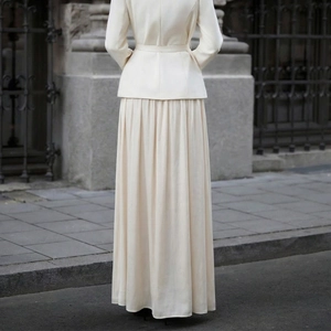 Elegant cream satin two-piece set featuring long-sleeved belted jacket and pleated maxi skirt