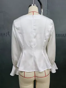 Dettaglio del retro di una camicetta di raso bianco con orlo peplum e polsini a volant