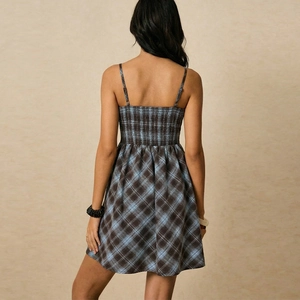 Brown plaid mini dress with smocked bodice and spaghetti straps from a back view perspective
