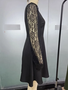 Detail of elegant black lace sleeves and smooth fabric of a long sleeve A-line dress