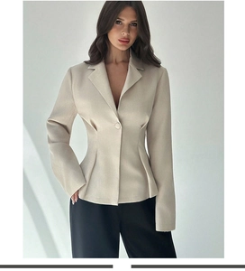 Dettaglio del blazer slim beige chiaro con pieghe in vita e chiusura a bottone singolo