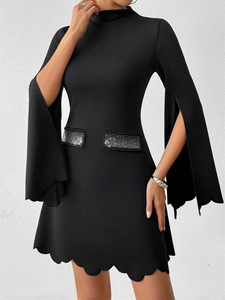Detail of slim black dress featuring slit sleeves and sparkling rhinestone pockets