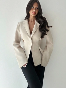 Dettaglio del blazer beige sciancrato da donna con chiusura a un bottone singolo