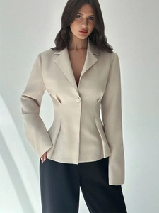 Dettaglio ravvicinato del blazer sfiancato beige che mostra la trama del tessuto e il taglio