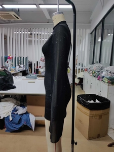 Détail d'une robe moulante noire élégante à manches longues avec paillettes argentées