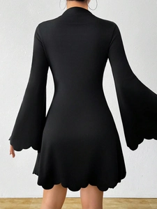 Detail of black mini dress featuring elegant scalloped edges and flared trumpet sleeves