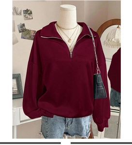 Detail of burgundy quarter-zip sweatshirt with a metallic zipper and soft fleece texture