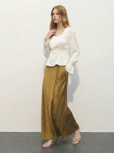 Vista a figura intera della camicetta bianca con scollo a U e gonna lunga giallo senape