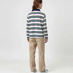 Polo a maniche lunghe a righe da donna e pantaloni kaki visti dal retro in studio