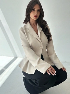 Dettaglio del blazer beige con peplo, chiusura a un bottone e design sciancrato