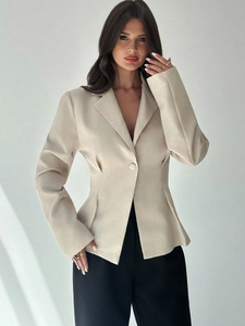 Dettaglio del blazer beige che mostra la trama del tessuto e il design a bottone singolo