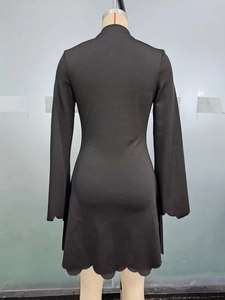 Detail view of scalloped edge hem and cuffs on black long sleeve slim A-line dress