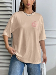 Oversized beige round neck T-shirt featuring a pink moon and sun graphic with blue jeans
