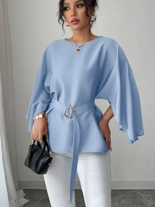 Detail of light blue batwing sleeve shirt with matching waist belt for elegant look