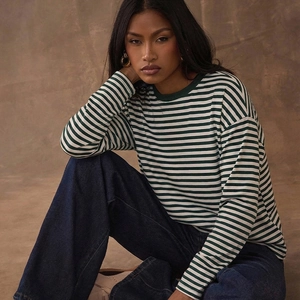 T-shirt femme à manches longues rayé vert et blanc avec un jean bleu foncé à jambes larges