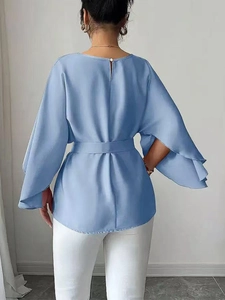 Back view of light blue satin blouse featuring elegant flared sleeves and waist tie detail