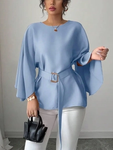 Detail of light blue satin top featuring elegant bell sleeves and gold buckle waist belt