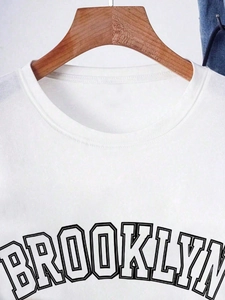 Close-up of white cotton crewneck t-shirt with Brooklyn graphic print detail