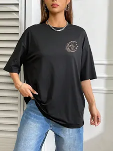 Detail of black oversized T-shirt featuring a gold moon and star print on the chest