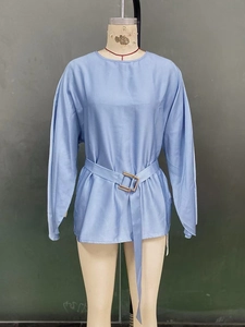 Detail of light blue satin blouse showing waist belt with gold square metal buckle
