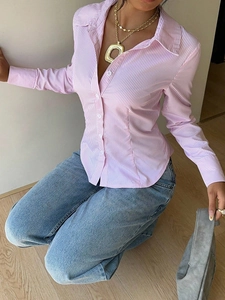 Detail of pink and white striped shirt featuring turn-down collar and white buttons