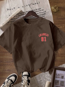 Detail des Los Angeles 91 Aufdrucks auf lockerem braunem Kurzarm-T-Shirt