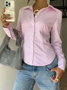 Detailed close-up of pink and white striped slim-fit shirt with curved hem and buttons
