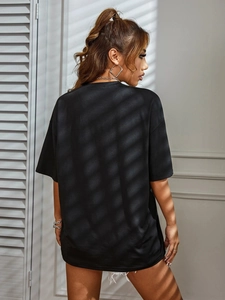 Fashionable black oversized T-shirt with shadows on the back and minimalist urban styling