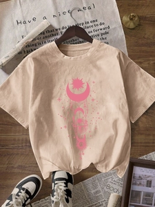 T-shirt beige à col rond avec motif graphique soleil et lune rose sur parquet bois