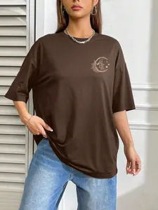 Detail of oversized dark brown T-shirt with celestial moon and sun print on chest