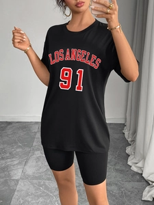 Détail de l'imprimé Los Angeles 91 sur T-shirt noir oversize et short de cycliste