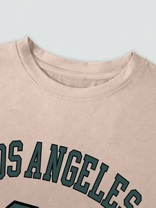Détail d'un t-shirt rose en coton avec imprimé Los Angeles vert et col rond