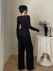 Vue arrière élégante du haut à paillettes noires et du pantalon large à taille haute