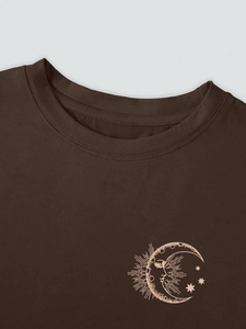Close-up of crescent moon and stars print on a dark brown crewneck cotton T-shirt