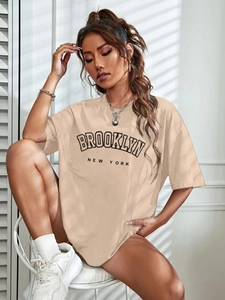 Detailed shot of the oversized beige Brooklyn New York graphic T-shirt with street style accessories