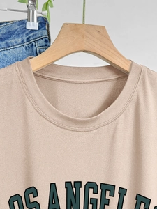 Gros plan détaillé d'un t-shirt beige en coton avec imprimé vert Los Angeles