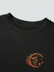 Detail of crew neck black cotton T-shirt featuring orange sun and moon print