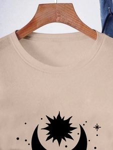 Close-up of beige crew neck T-shirt with mystic sun, moon and stars print detail