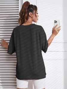 Rear view of black oversized short-sleeved cotton T-shirt with a loose drop-shoulder fit