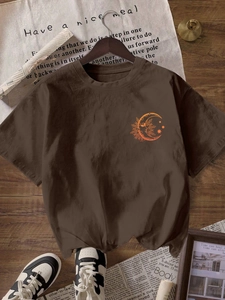 Detail of brown cotton t-shirt featuring retro celestial moon face and star print
