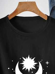 Detail of crew neck black cotton t-shirt with celestial sun and moon graphic print